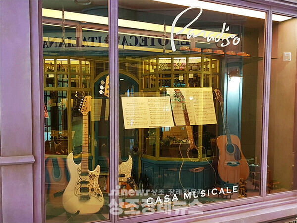 ▲ ‘홈’ 내부는 유럽의 거리를 연상시키는 가게들로 꾸몄다. 이 가게는 기타와 악보를 배치해 음악 가게로 꾸몄다. 명품으로 꾸민 쇼윈도도 있다. 사진-김충현